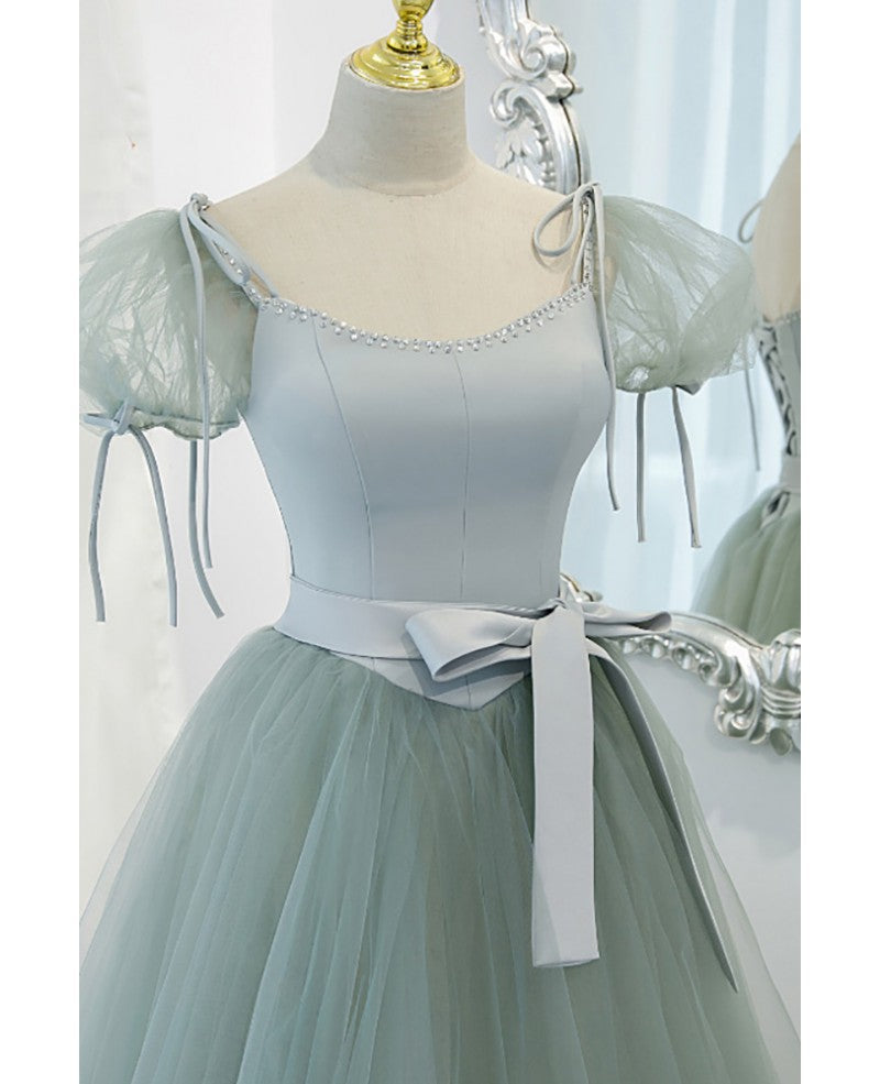 Unico ed elegante abito da ballo verde menta con scollo quadrato, maniche corte e soffice, cintura con fiocco verde menta e spalline scoperte sulla schiena e abito da ballo lungo fino al pavimento.